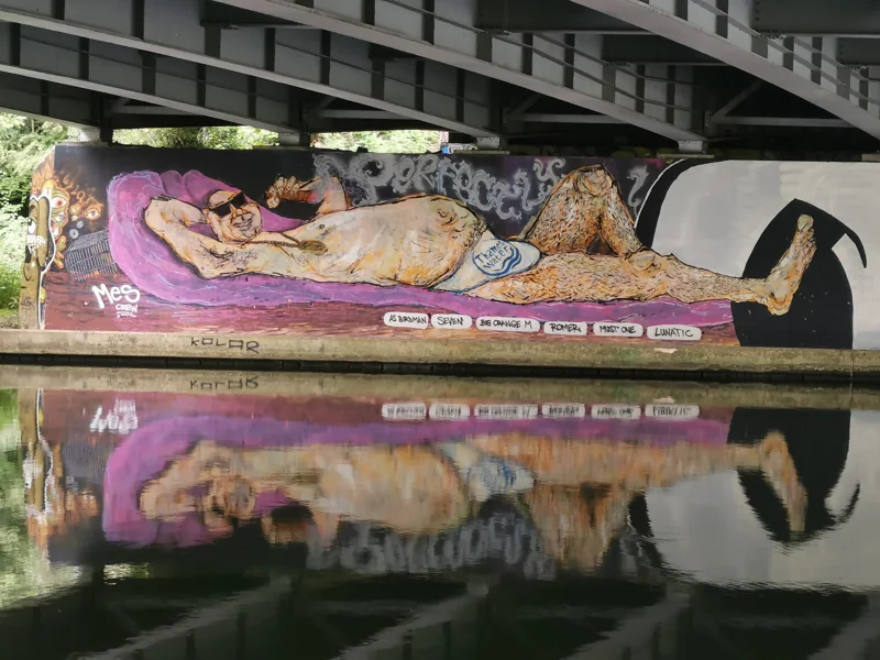 A canal-side mural of a water-company boss lounging in a Thames Water swimsuit